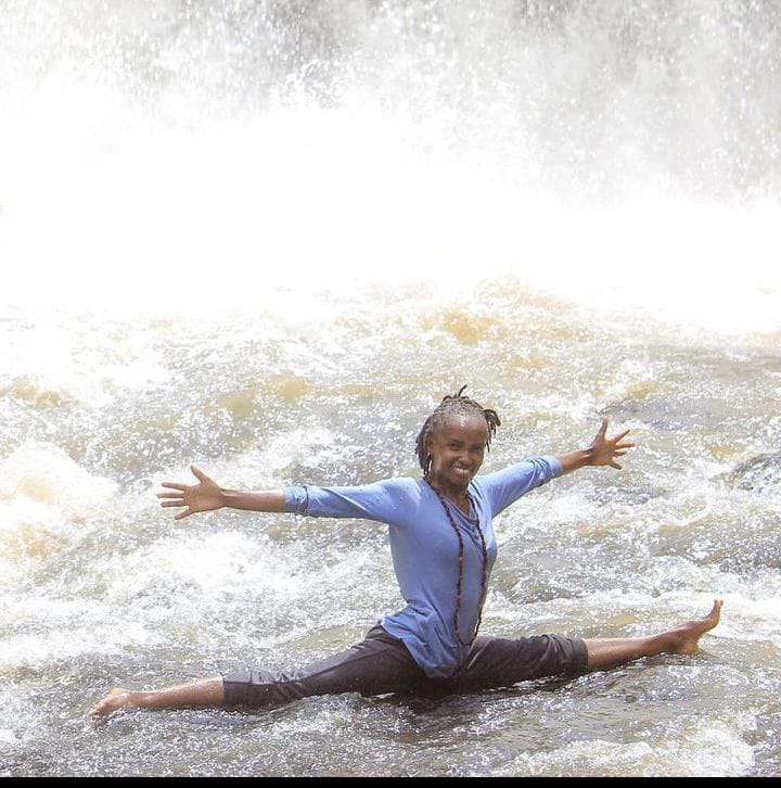 Mwihaki doing a full split at the Mukungai river waterfall.