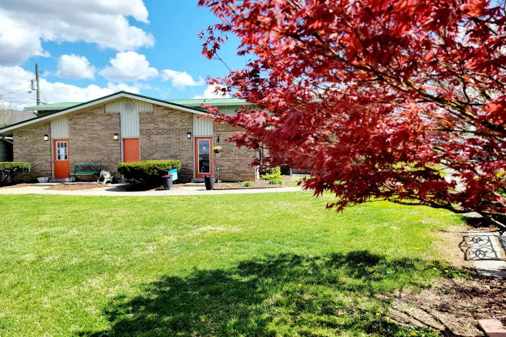 Bridgewater Retreat Apartments brick leasing office with a green lawn in front and a red-leafed tree in the foreground