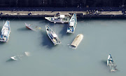 An aerial view shows capsized boats believed to be affected by the tsunami caused by an underwater volcano eruption on the island of Tonga at the South Pacific, in Muroto, Kochi prefecture, Japan, in this photo taken by Kyodo on January 16 2022. 