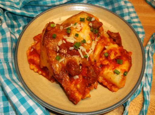 Plated ravioli casserole on counter with apron.