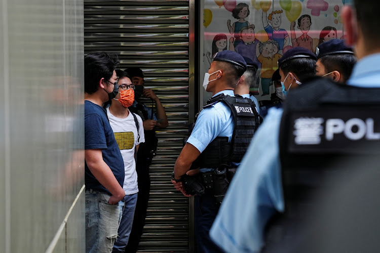 Police officers question pro-democracy protesters in Hong Kong, China, May 8 2022. Picture: LAM YIK/REUTERS