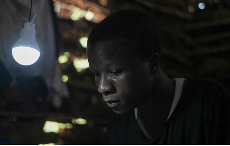 Mohamed Karisa utilizing the solar lantern during his studies.