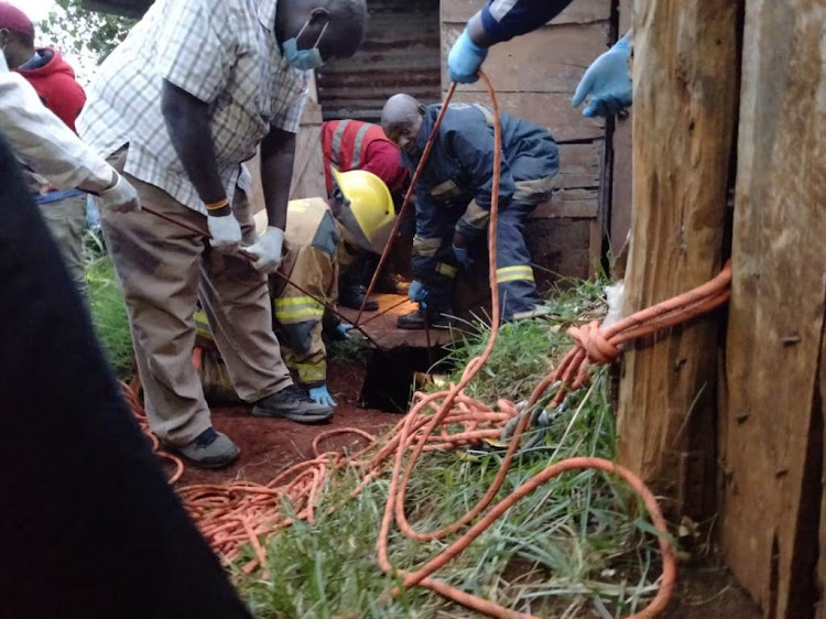 Kamwanya villagers in Githunguri assist DCI officers to pull out exhibits from a toilet.