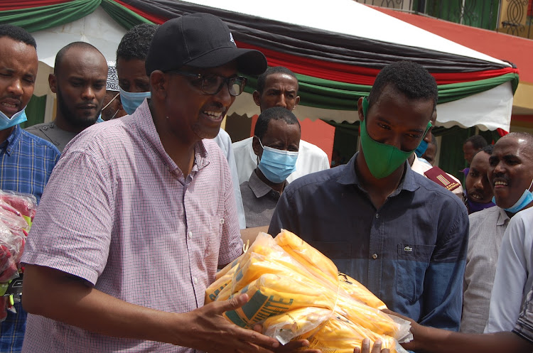 Garissa township MP Aden Duale issues uniforms and playing kits to Musa Maalim, the captain of Real white football club at his residence on Sunday.