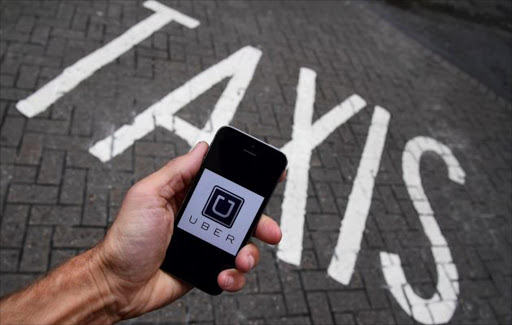 A photo illustration shows the Uber app logo displayed on a mobile telephone.