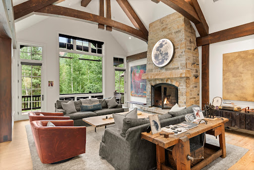 Salon avec cheminée en pierre et poutres apparentes - louer Maison de luxe à Aspen, 5 chambres