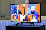 Xi Jinping, China's president, top left, Charles Michel, president of the European Council, top right, Angela Merkel, Germany's chancellor, bottom right, Emmanuel Macron, France’s president, bottom center, and Ursula von der Leyen, European Commission president, on a monitor during a EU-China investment accord virtual meeting in the Europa Building in Brussels, Belgium, on Wednesday.