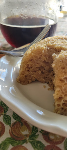 churro mug cake on white plate with cup of coffee