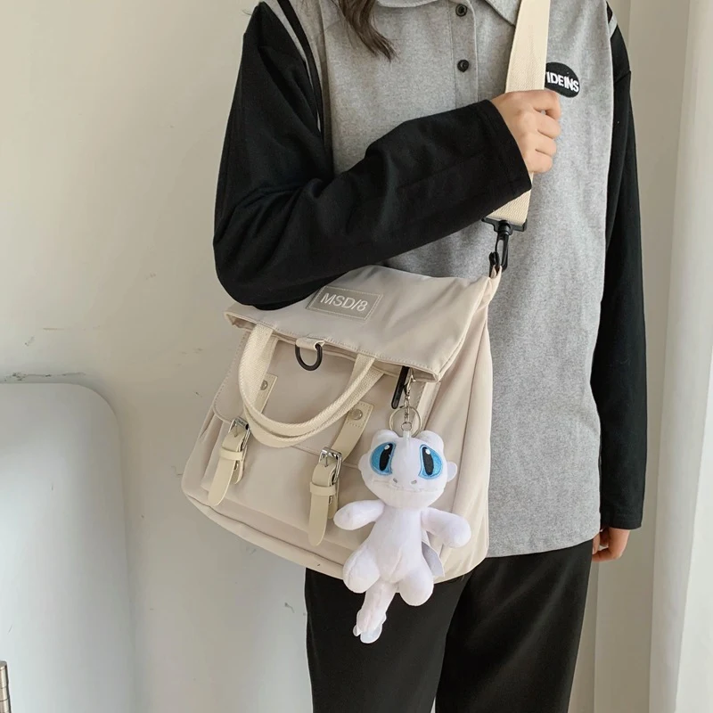 Sac bandoulière en toile Harajuku pour femme avec pendentif dessin animé, idéal pour transporter vos essentiels avec style et confort.