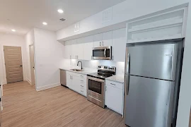 Kitchen area with white cabinetry, stainless steel appliances, and granite countertops