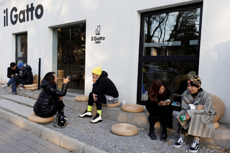 People sit outside a cafe after some curbs were lifted as coronavirus disease outbreaks continue in Beijing on December 7 2022. Picture: REUTERS/THOMAS PETER