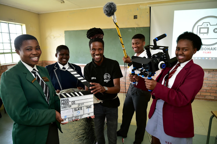 Project leader Thula Soqaga shows, from left Azola Dingana, 17, of Coselelani High, Ambesa Brikwa, 16 (Cimgani), Simamkele Fina, 16, (Ndyebo) and Zimkita Gotyana (Soqhayisa) how to use the equipment required to film a scene