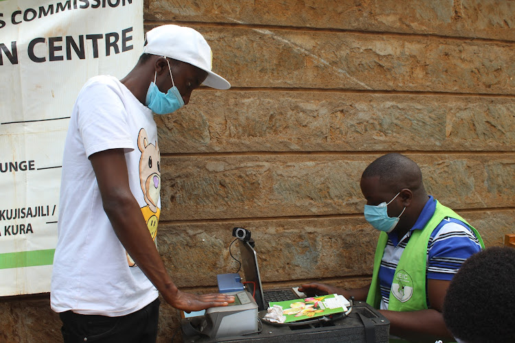 A man registers as a voter along Gakere road in Nyeri town on Thursday.