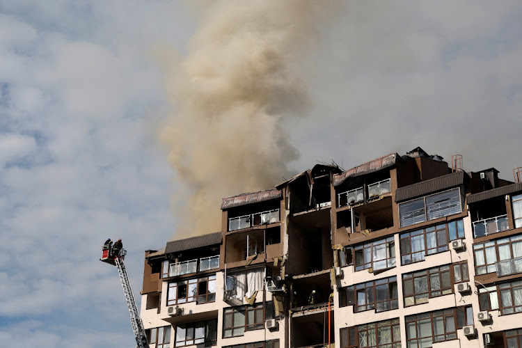 Firefighters worker to put out a fire as smoke rises from a residential building damaged by a Russian missile strike, as Russia's attack on Ukraine continues, in Kyiv, Ukraine June 26, 2022.