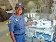 Constable Nomsa Mashaba next to the hospital incubator with the baby who was found abandoned in Pretoria on Monday.