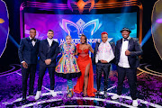 Award-winning singer-songwriter Holly Rey (centre) wins The Masked Singer SA. She stands alongside detectives Sithelo Shozi and Skhumba on her left and J'Something as well as host of the show Mpho Popps on her right. 