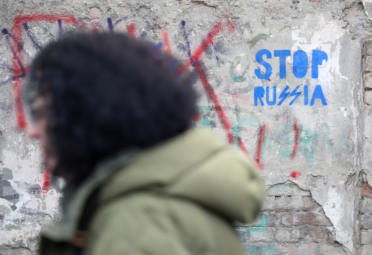 A pedestrian walks past an anti-Russian graffiti in a street in Tbilisi, Georgia, on February 15 2023. Picture: IRAKLI GEDENIDZE/REUTERS