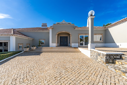 Modern villa entrance with paved driveway in this luxury house for sale in Sintra ($4,994,135)