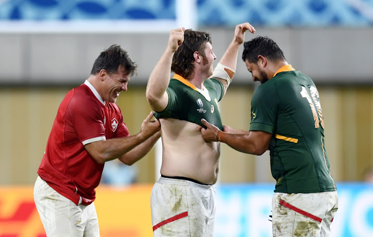 South Africa's Schalk Brits (L) and Malcolm Marx (R) exchange a match jersey with a Canadian player after the match.