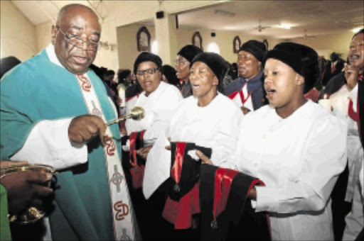 solemn pledge : Father Theophillas Malotsa of Our Lady of Peace Catholic Church in Kagiso on the West Rand blesses congregants during the Sacred Heart Sodality Investitures ceremony Photo: Bafana Mahlangu