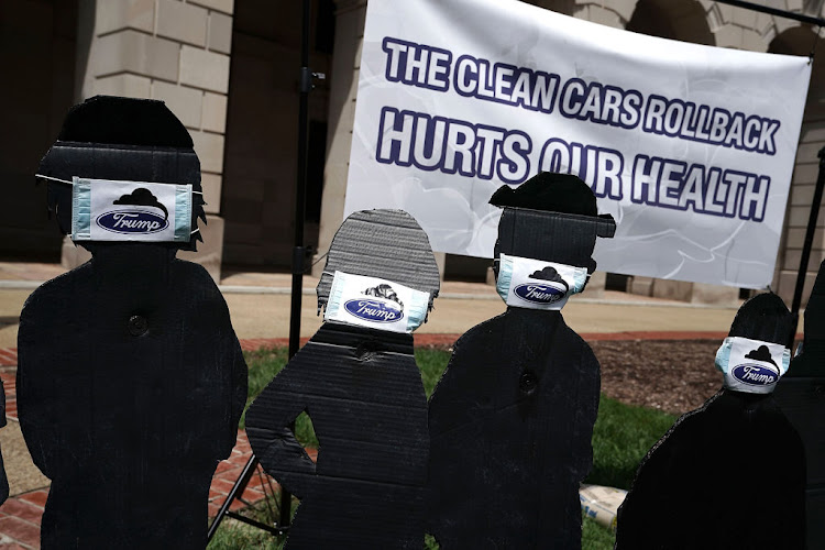 Cardboard cutouts of children wearing surgical masks are seen during a protest outside the Environmental Protection Agency (EPA) on August 2, 2018 in Washington, DC. Advocacy group Public Citizen held a demonstration opposing the Trump Administration's proposed rollback of clean car standards.