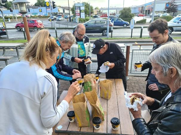 A group of people sitting at a table eating food

Description automatically generated with low confidence