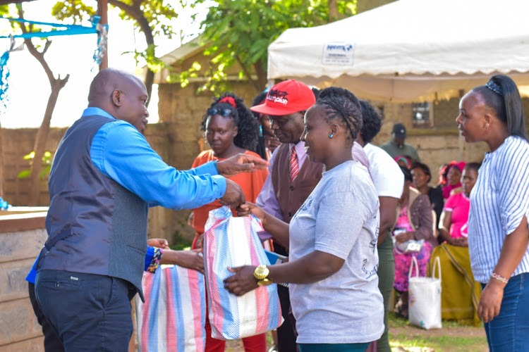 Shofco Founder and CEO Dr. Kennedy Odede (left) distributing foodstuffs at a past event. He has offered 19 Shofco sites countrywide to be used as holding centres for flood victims.