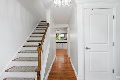 Hallway with stairs, door and visible kitchen in this luxury property for sale in Stafford ($589,000)