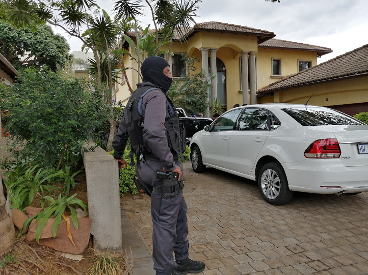 A member of the national intervention unit stands guard during a raid by members of the Hawks and AFU at the plush home of Hlenga Sibisi - accused of bribing an eThewkwini official for tenders - in Umhlanga, north of Durban, on October 10 2019.