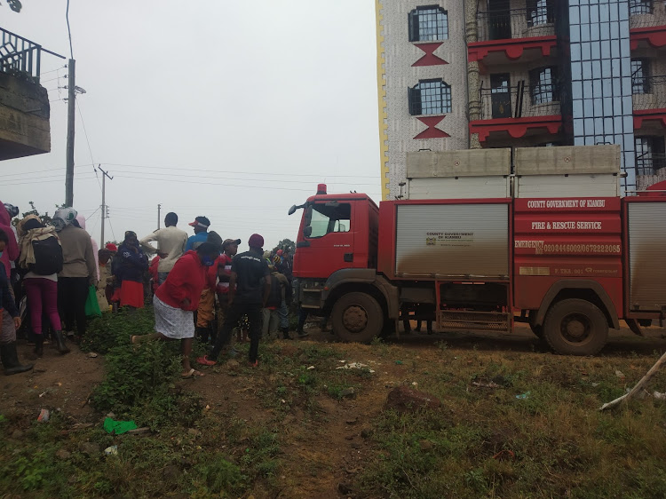 Locals mill around the building where three men plunged to their death in an underground water reservoir in Ngongwa, Thika, on Monday