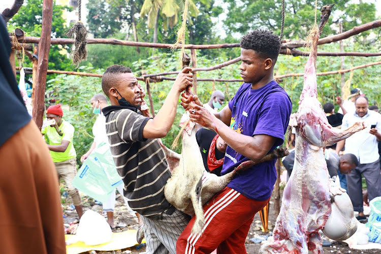 Saidi Athumani and Rashid Yakub skin a goat near Memon Mosque in Mvita constituency on Friday.