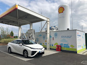 The Toyota Mirai next to a hydrogen refuelling pump at a highway service station near London.