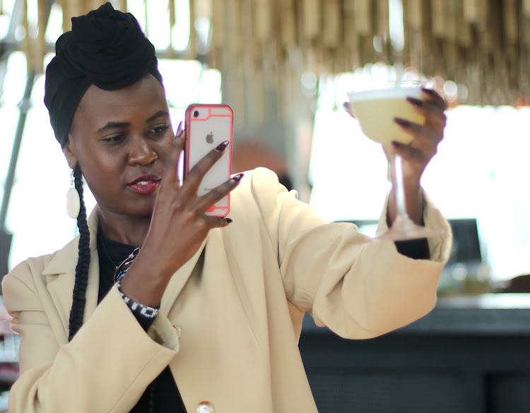 Diane Nthurima takes a photo of Pisco Granadilla