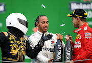 Sebastian Vettel took a dim view of race mascot 'Mario Achi', left, trying to join the champagne celebrations with a selfie stick.