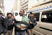 GOTCHA: Metro police officers arrest taxi drivers in the
Johannesburg CBD during operation Nomakanjani. Pic: Antonio Muchave. 23/06/2009. © Sowetan.