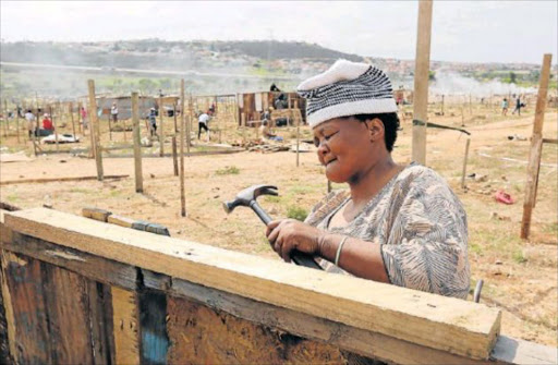 Tamara Dingana, 51, a former backyard dweller from Izinyoka, erects her shack at ‘Malema Village’ Picture: Werner Hills