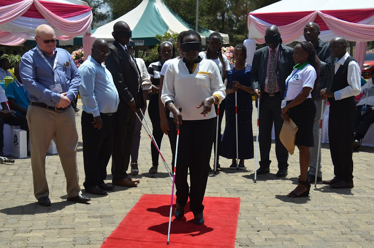 TVET PS Esther Muoria uses a white stick during a demonstration exercise on how visually impaired people are trained to walk at Machakos Technical Training Institute for the Blind on March 8, 2023.