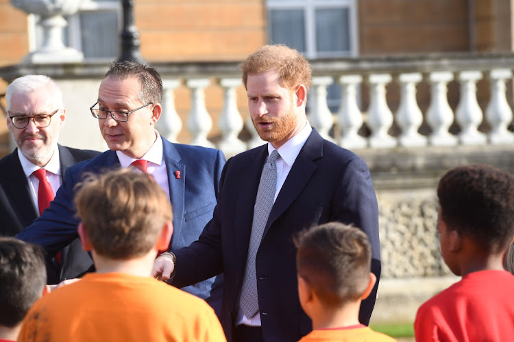 Prince Harry attends the draw for the Rugby League World Cup where he meets children from a local school who played rugby league in Buckingham Palace gardens yesterday