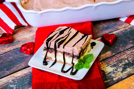 A slice of Italian Love Cake drizzled with chocolate.