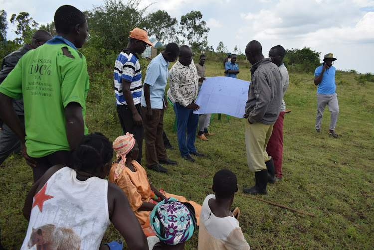 Human rights defender Evans Oloo shows residents a land map in Kachuth location in Kwabwai ward , Ndhiwa constituency on April 1,2024