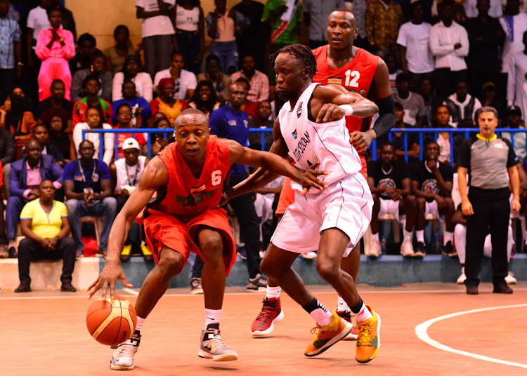 Kenya's Erick Mutoro (L) shields the ball from Tenny Puot of South Sudan during the Fiba AfroBasket preQualifiers at Nyayo early this year