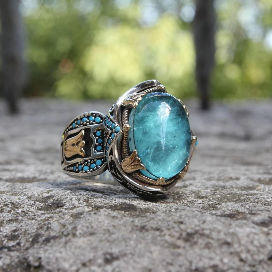 Bague en pierre précieuse bleue sculptée bicolore, un bijou élégant pour sublimer votre style et vous démarquer avec raffinement.