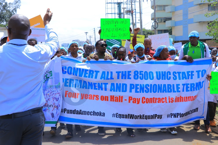 Healthcare workers hired by government under the Universal Healthcare program hold placards as they demonstrate on April 8, 2024.