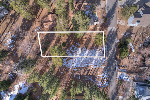 Wooded land with snow on ground in this luxury property for sale in Big Bear Lake ($1,046,000)