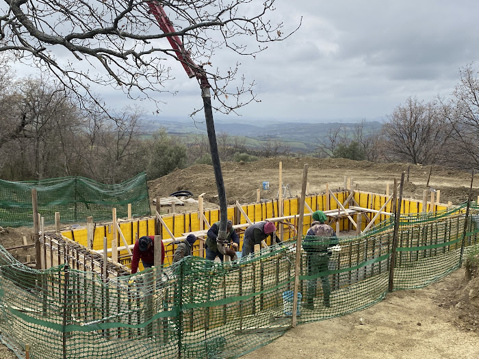 Constructing Santa Pia swimming pool, workman pouring concrete 