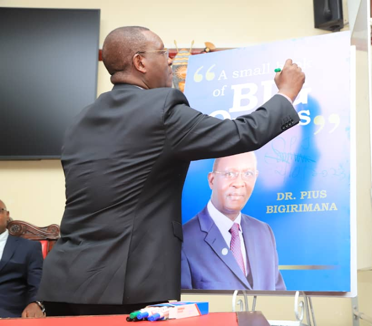 Dr. Bigirimana signing on one of the copies of his book