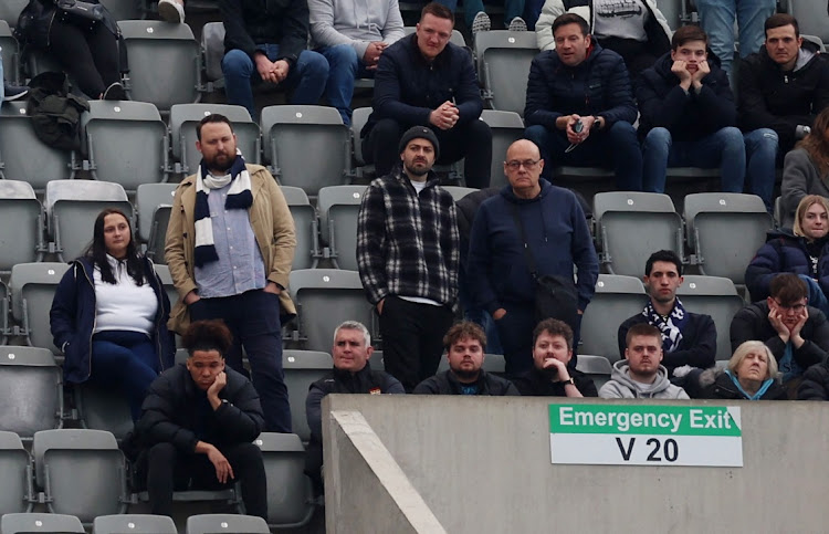 General view of Tottenham Hotspur fans amongst empty seats in the stands.