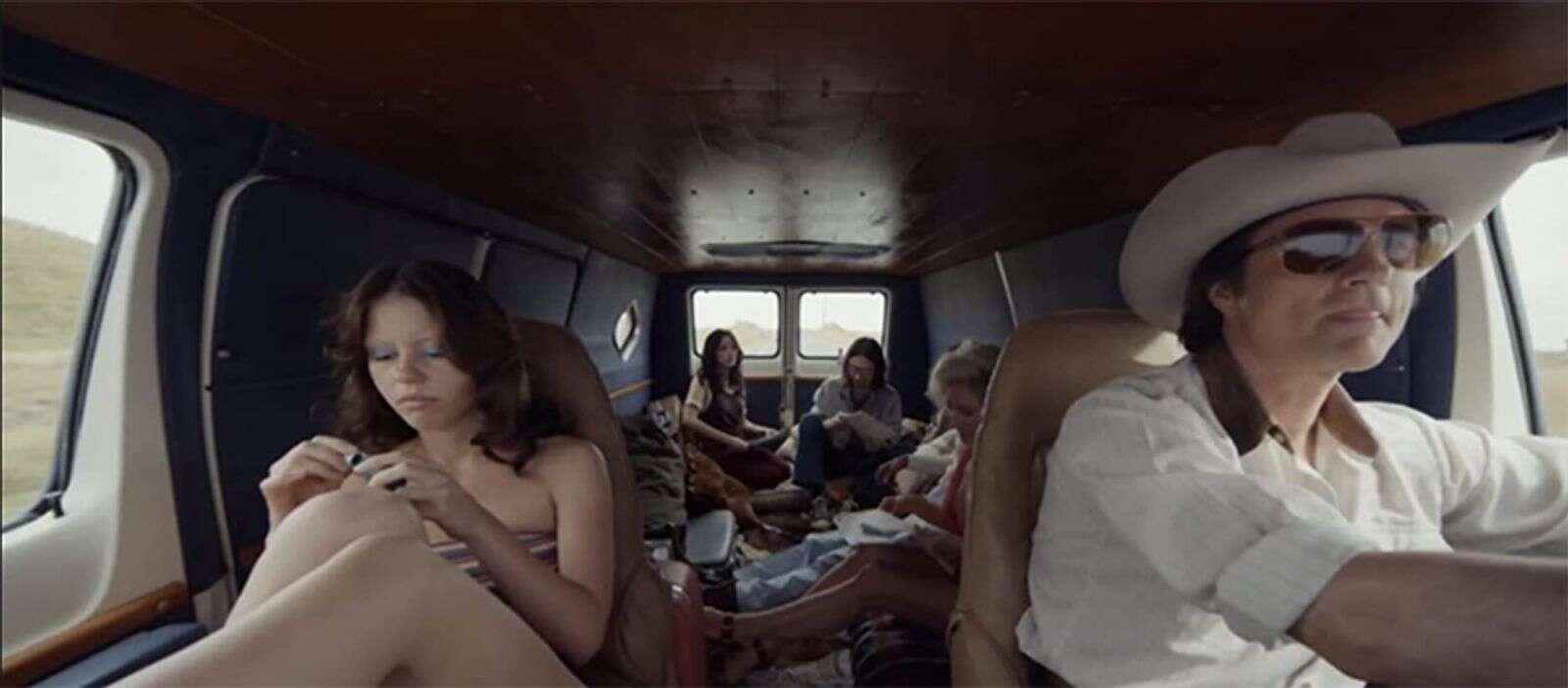 The crew and stars of The Farmer's Daughters sit together in their van, with Maxine in the passenger seat and Wayne driving.