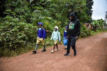 Deputy President Rigathi Gachagua walks with students on their way to school in Meru County on June 9, 2023.