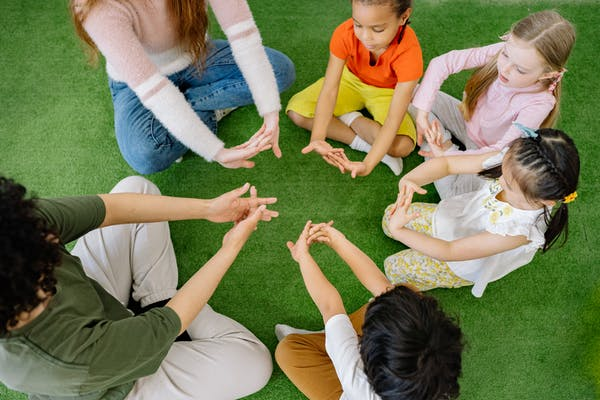 Children seated in a circle playing